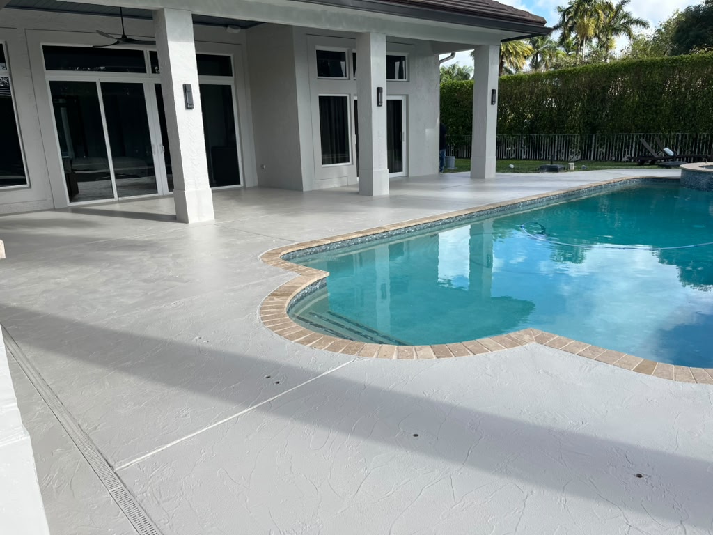 Concrete pool deck with travertine coping