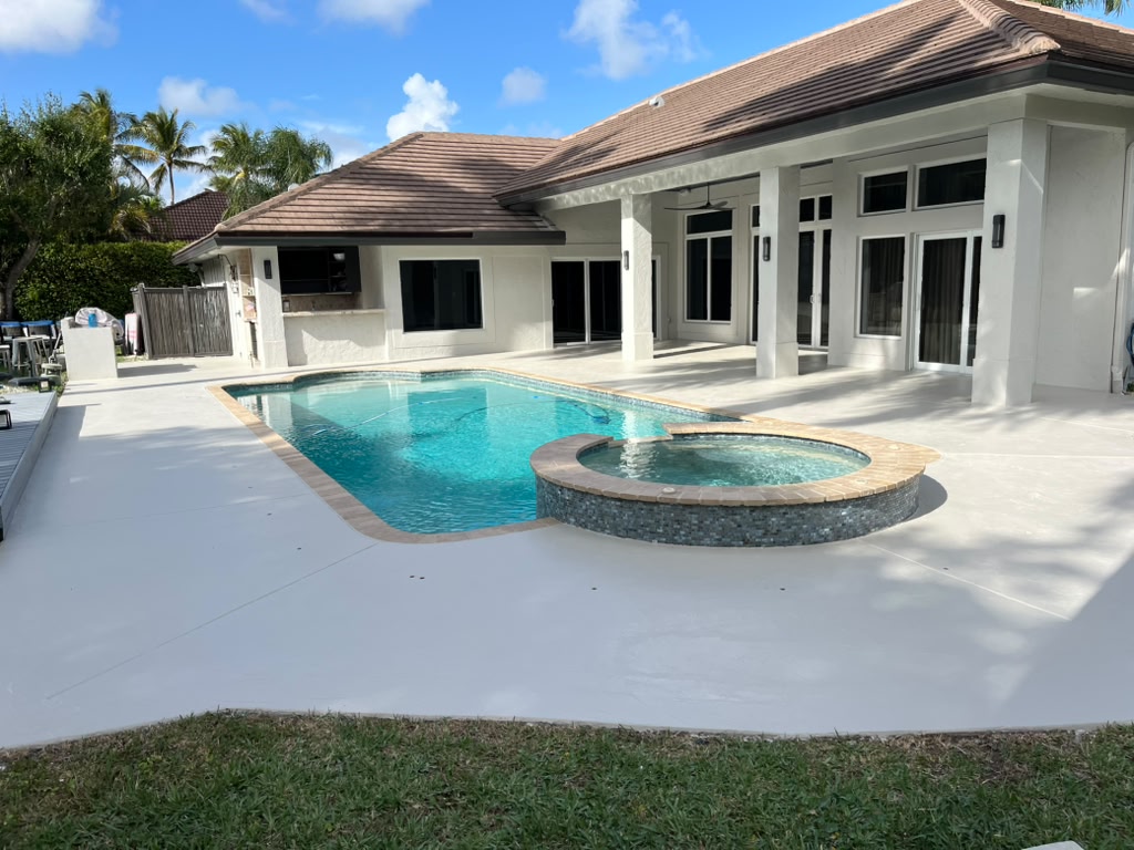 Large concrete pool deck with spa and travertine accents
