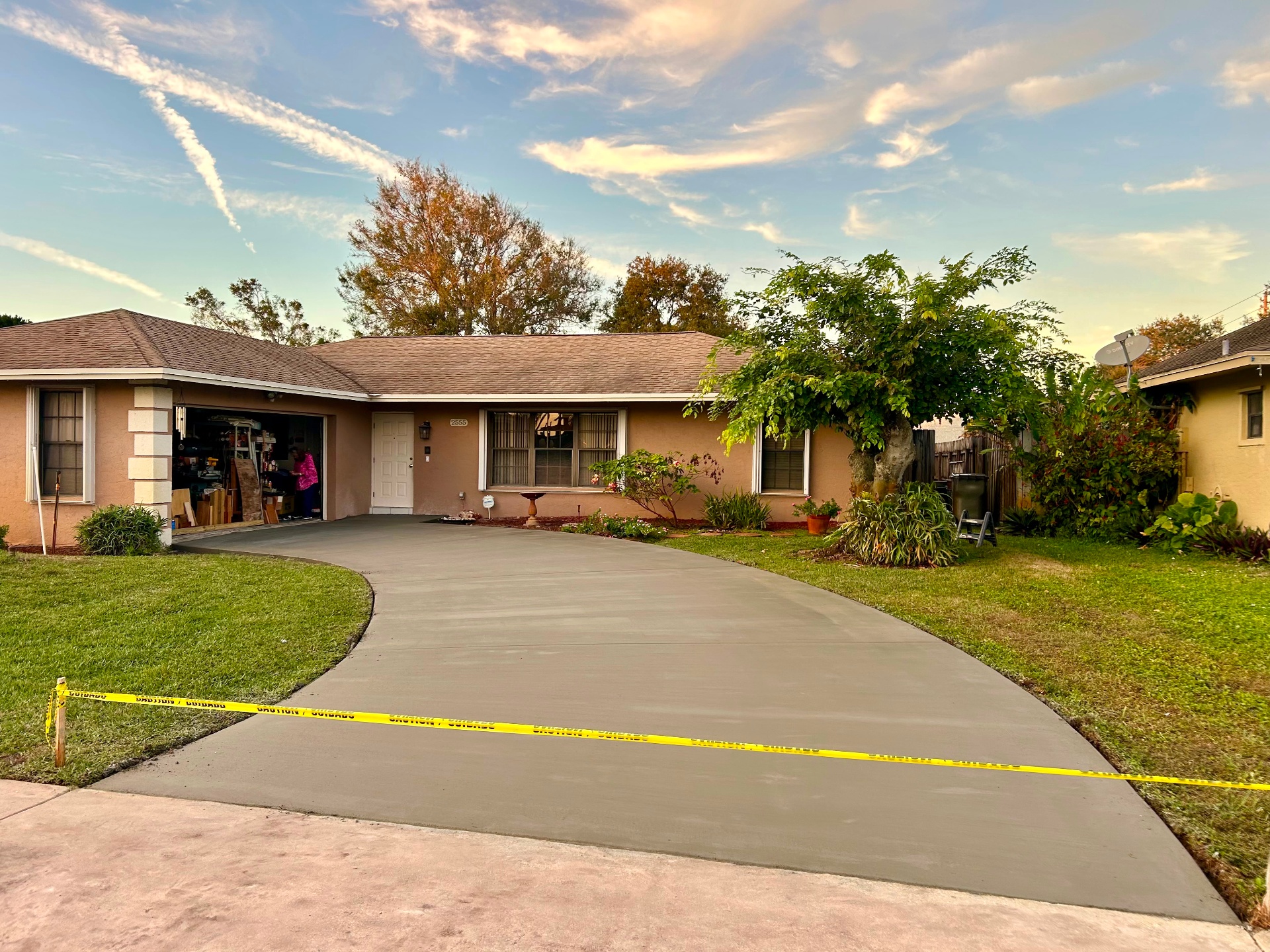 Smooth-finish curved residential concrete driveway at sunset